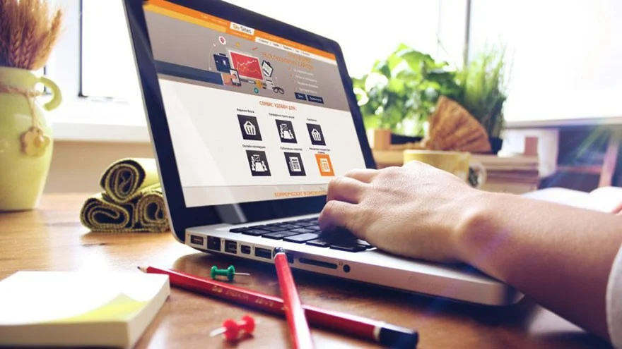 Web tasarım çalışması — dizüstü bilgisayarda web sitesi arayüzü üzerinde çalışan tasarımcı